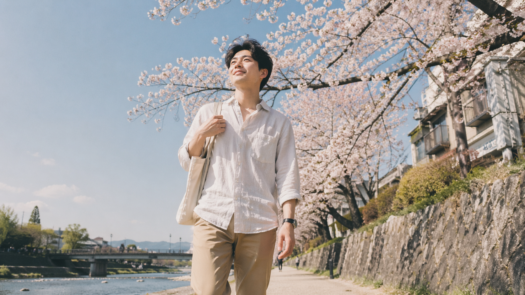 鴨川沿いを歩く男性